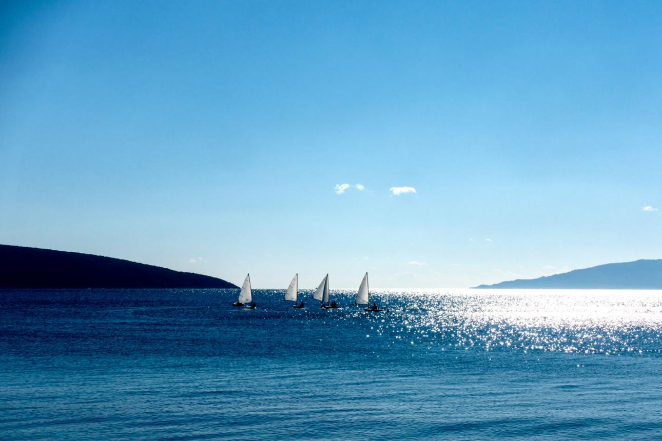 Dériveurs naviguant ensemble sur une mer lumineuse