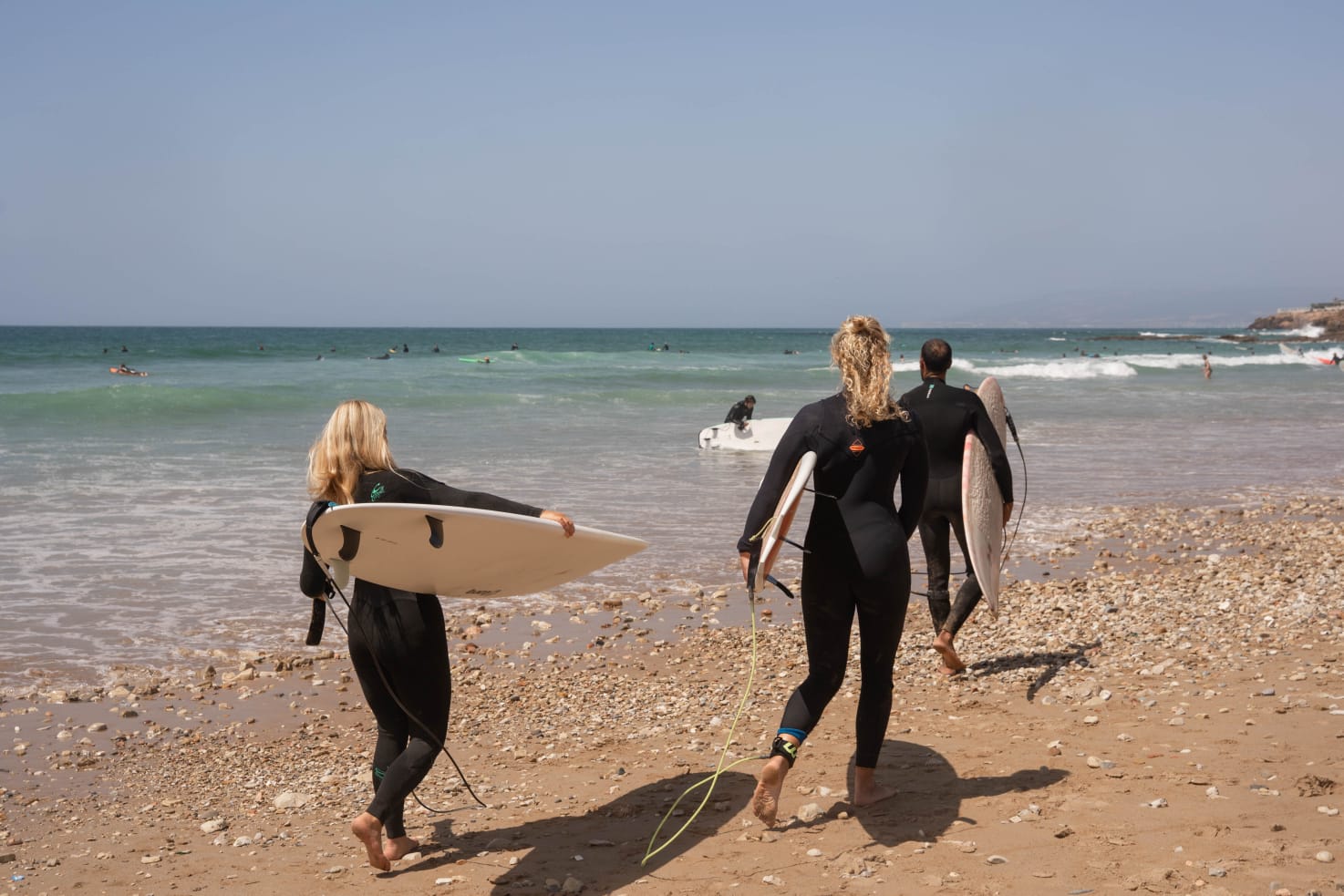 Un groupe de surfeurs marchant vers l'océan avec leurs planches
